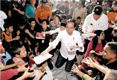  ?? AFP ?? Indonesian President Joko Widodo interacts with children as he visit earthquake-affected people at a shelter in Lombok. —