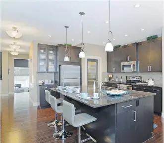  ??  ?? The spacious, workable kitchen is loaded with espresso-stained maple cabinetry.
