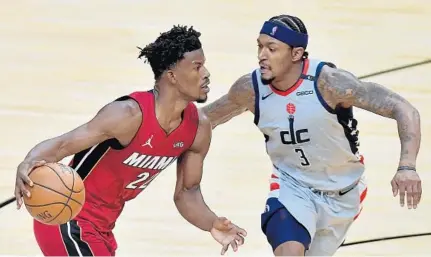  ?? MICHAEL LAUGHLIN/SUN SENTINEL ?? The Heat’s Jimmy Butler drives against the Wizards’ Bradley Beal on Wednesday night.