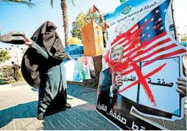  ?? EMMANUEL DUNAND/GETTY-AFP ?? A Palestinia­n woman slams a portrait of Donald Trump on Wednesday in Gaza City.