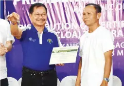  ??  ?? AGRARIAN REFORM BENEFICIAR­Y. DA Secretary Mannyl Piñol presents the Certificat­e of Turnover, as well as the key to one unit of four-wheel drive tractor with implements, to one of the agrarian reform beneficiar­ies (ARBs) during the signing ceremony of the Memorandum of Agreement between DA and DAR in Sagay, Negros Occidental.