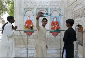  ?? ?? A Pakistani Hindu teen takes selfie with his phone Oct. 26 while he and others visit the Sadhu
Bela temple.
