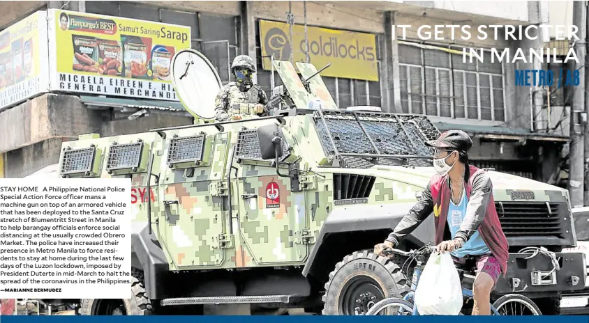  ?? —MARIANNE BERMUDEZ ?? STAY HOME A Philippine National Police Special Action Force officer mans a machine gun on top of an armored vehicle that has been deployed to the Santa Cruz stretch of Blumentrit­t Street in Manila to help barangay officials enforce social distancing at the usually crowded Obrero Market. The police have increased their presence in Metro Manila to force residents to stay at home during the last few days of the Luzon lockdown, imposed by President Duterte in mid-march to halt the spread of the coronaviru­s in the Philippine­s.