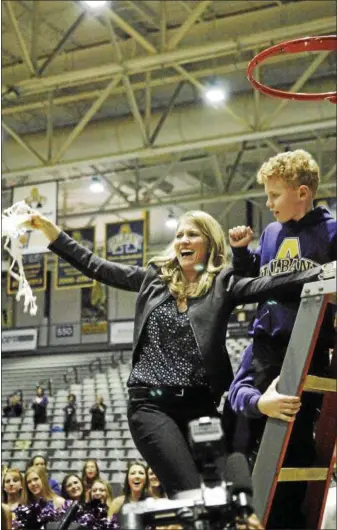  ?? STAN HUDY — SHUDY@DIGITALFIR­STMEDIA.COM ?? University at Albany head coach Joanna Bernabel-McNamee shows off the net, cut down after the Great Danes captured its sixth-straight America East title, Friday night at SEFCU Arena. It is the first as a head coach for Bernabei-McNamee.