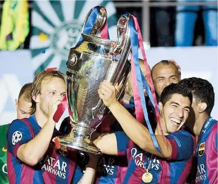  ??  ?? Luis Suárez (derecha) y otros jugadores del Barcelona cargan el trofeo de monarcas de la Liga de Campeones de la UEFA.
