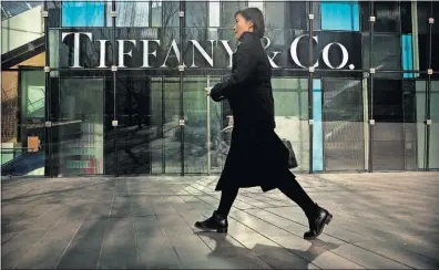  ?? [MARK SCHIEFELBE­IN/THE ASSOCIATED PRESS] ?? More and more shoppers are walking past Tiffany &amp; Co. at a shopping mall in Beijing and other luxury brand stores as China’s economy slows down. Chinese customers spend $90 billion a year on jewelry, clothes and other high-end goods.