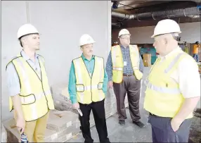  ?? Westside Eagle Observer/MIKE ECKELS ?? Decatur Mayor Bob Tharp (right) talks to Donny Epps (left) and Gentry Mayor Kevin Johnson about the new Simmons plant, while Jeff Thacker (background) watches work going on outside the window. The four were part of the July 2 tour of the new poultry plant currently under constructi­on on Arkansas Highway 59 between Gentry and Decatur.