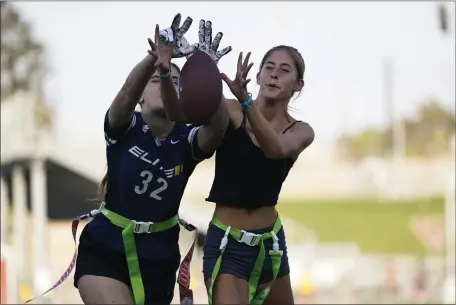  ?? ASHLEY LANDIS — THE ASSOCIATED PRESS FILE ?? Aly Young, 17, left, and Shale Harris, 15, reach to catch a pass as they try out for the Redondo Union High School girls flag football team on Thursday, Sept. 1, 2022, in Redondo Beach, Calif. California officials are expected to vote Friday on the proposal to make flag football a girls’ high school sport for the 2023-24 school year.