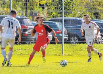  ?? FOTO: ALEXANDER HOTH ?? Kressbronn­s Tim Siegel (rotes Trikot) und der SV Kressbronn unterliege­n im Derby gegen Brochenzel­l mit 0:1 (links Jörg Baumann, daneben Manuel Burkhart).