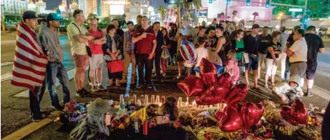  ?? Foto: Nick Otto, dpa ?? Las Vegas trauert: An einer Art Gedenkstät­te legen Menschen Blumen und Kerzen zur Erinnerung an die Opfer des Massenmörd­ers Stephen Paddock nieder.