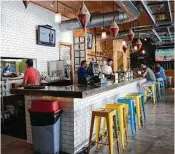  ??  ?? Repurposed light fixtures and pops of yellow and turquoise greet diners at South Bank Seafood Bar.