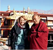  ??  ?? Sonia Bressler pose avec un moine bouddhiste tibétain au Tibet.