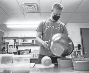  ?? WILLIAM GLASHEEN/USA TODAY NETWORK-WISCONSIN ?? FourOne Food Group co-owner and chef David Bennett assembles meals for Prepd, a meals-to-go food service that became the biggest part of the business during the pandemic.