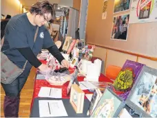  ?? GREG MCNEIL/CAPE BRETON POST ?? Riki Lee Christmas adjusts the display for the silent auction hosted by applied media and communicat­ion arts students at NSCC Marconi Campus. The silent auction featured many of the students’ creations.