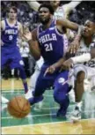  ?? CHARLES KRUPA — ASSOCIATED PRESS ?? Sixers center Joel Embiid falls to the floor as the ball bounces out of bounds after hitting him, as Boston’s Terry Rozier, right, points during the final seconds of Game 5 in Boston. The Sixers gave up a lead in the final two minutes en route to a...