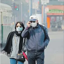  ?? ERIC RISBERG
THE ASSOCIATED PRESS ?? A couple in San Francisco wear masks while walking at Fisherman's Wharf through smoke and haze from wildfires on Friday.