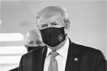  ?? PATRICK SEMANSKY/AP ?? President Donald Trump wears a mask Saturday at Walter Reed National Military Medical Center in Bethesda, Maryland.