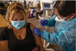  ?? Tribune News Service/los Angeles Times ?? Gabriela Martinez, right, vaccinates Blandly Amaya, left, at South Central Family Health Center on Jan. 27 in Los Angeles.