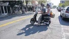  ?? TANIA SAVAYAN, THE (WESTCHESTE­R, N.Y.) JOURNAL NEWS ?? Steven and Evelina Quinones of south Nyack, both 30, drive off on their Vespa after shopping at the farmers market Sept. 13.