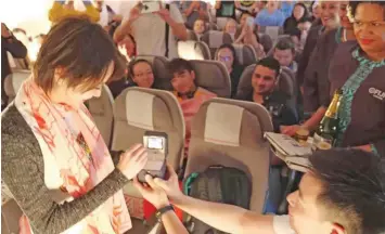  ??  ?? Engaged: Peng Wu proposes to Yvonne Lai (left) onboard Fiji Airways flight FJ392 from Hong Kong to Nadi on November 3, 2018. Shratika Naidu