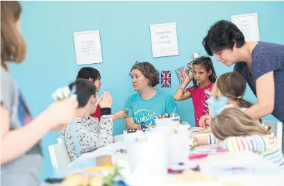  ?? RENÉ JOHNSTON/TORONTO STAR ?? Jennifer Thompson, owner of Create Art Studio, shows kids how to make items they can wear while watching the wedding on TV.