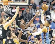  ?? [AP PHOTO] ?? Oklahoma City Thunder’s Russell Westbrook goes for a shot over Brooklyn Nets’ Caris Levert, center, and Timofey Mozgov in Thursday night’s game in Mexico City.