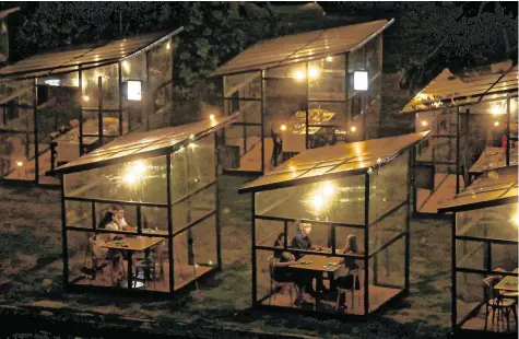  ?? PHOTO: PILAR OLIVARES/ REUTERS ?? Business as usual: Diners sit inside protective booths at the Sushi das Artes restaurant in Rio de Janeiro, Brazil.