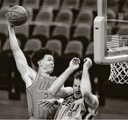  ?? Eric Gay / Associated Press ?? Oklahoma City center Isaiah Roby scores over Spurs center Jakob Poeltl during the second half of Thursday night’s game.