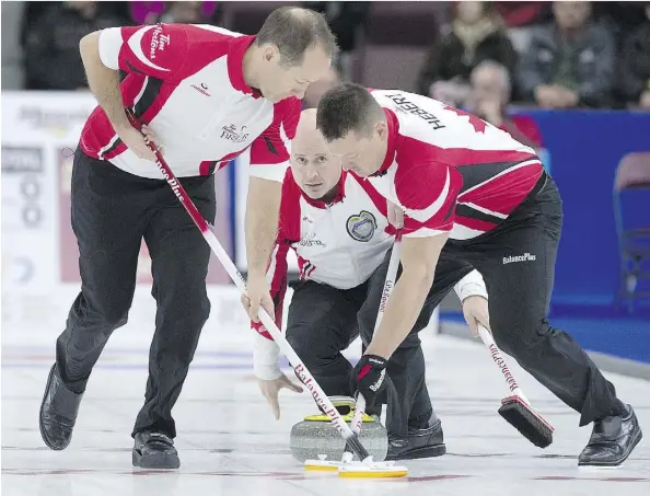  ?? ANDREW VAUGHAN/THE CANADIAN PRESS ?? Team Canada skip Kevin Koe watches his rock as Brent Laing, left, and Ben Hebert sweep against Manitoba at the Brier in St. John’s, N.L., on Thursday. Koe’s rink won the match 6-3 before losing 7-6 to Brad Gushue, the hometown favourite, in the late...