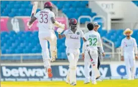  ?? AFP ?? Jayden Seales (L) and Kemar Roach (2L) celebrate after beating Pakistan at Sabina Park.