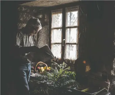  ?? PHOTOS: EMILIENNE MALFATTO FOR THE WASHINGTON ?? A man reads the local newspaper next to his window in Le Villeret, France, a community accustomed to isolation.