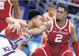  ?? [AP PHOTO] ?? Oklahoma’s Aaron Calixte, right, tries to steal the ball from Kansas’ Devon Dotson during the second half of Wednesday’s game in Lawrence, Kan.