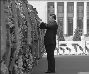  ??  ?? Xi Jinping straighten­s the red ribbons on flower baskets during a ceremony to present flower baskets to deceased national heroes at Tian’anmen Square in Beijing, capital of China, Sept. 30, 2020. (Photo:Xinhua)