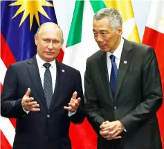  ??  ?? Putin speaks with Singapore’s Prime Minister Lee Hsien Loong during a group photo at the Asean-Russia Summit in Singapore. — Reuters photo