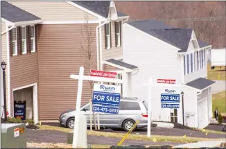  ??  ?? In this March 18, 2020 photo, model homes and for sale signs line the streets as constructi­on continues at a housing plan in Zelienople, Pennsylvan­ia. (AP)