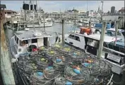  ?? Eric Risberg Associated Press ?? CRAB POTS sit in wait at Fisherman’s Wharf in San Francisco. Exports to China have taken a hit.