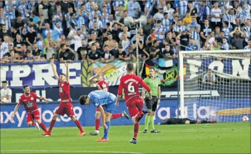  ??  ?? CELEBRACIÓ­N. Los jugadores del Deportivo festejan el fortuito gol de Bergantiño­s con Munir, portero del Málaga, abatido al fondo.