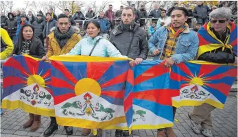  ?? FOTO: DPA ?? Sechs Aktivisten im Mainzer Publikum halten aus Protest gegen Chinas Politik tibetische Flaggen hoch. Die Spieler der chinesisch­en U20-Nationalma­nnschaft verließen daraufhin den Platz.