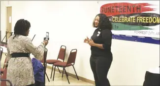  ?? Brodie Johnson • Times-Herald ?? The month-long celebratio­n of Juneteenth kicked off on Tuesday with a health fair in Madison. Taraji Kiyumbi, left, films Angela Wilburn as she opens the celebratio­n by telling people about the upcoming events regarding Juneteenth. According to Wilburn, people from other cities and states have already purchased tickets to some of the events scheduled for later this month in Forrest City.