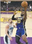  ?? AP file photo ?? The Lakers’ LeBron James shoots as Magic center Nikola Vucevic defends during an NBA game on Jan. 15.