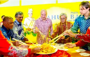  ?? Bernama photo — ?? Sultan Nazrin (centre) joins Saarani (left) and others in the yee sang toss.