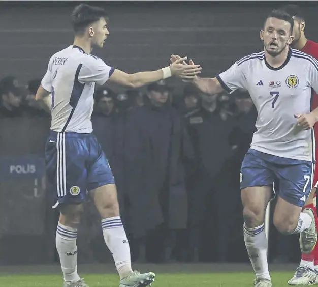  ?? ?? ↑ Scotland midfielder John Mcginn, centre, celebrates with team-mates after scoring with a stunning strike to reduce the deficit but an equaliser proved elusive as Turkey secured a 2-1 win in last night’s internatio­nal friendly at Diyarbakir Stadium