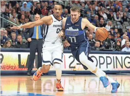  ??  ?? Memphis Grizzlies guard Avery Bradley (0) defends as Dallas Mavericks forward Luka Doncic (77) tries to drive to the rim on March 2 in Dallas. RICHARD W. RODRIGUEZ/AP