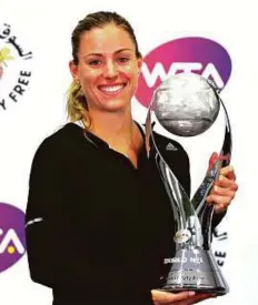  ?? Reuters ?? Angelique Kerber holds the WTA year-end No. 1 trophy on the sidelines of the WTA Finals in Singapore yesterday.