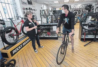  ?? MATHEW MCCARTHY WATERLOO REGION RECORD ?? Lori Lackenbaue­r, owner of King Street Cycles, talks to Artem Kobelev about a bike on Wednesday. A surge in biking interest has led to shortages, she says.