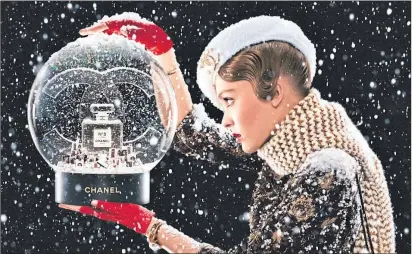  ??  ?? Actress and model Lily-Rose Depp peers into a Chanel No. 5 snowglobe in a 2019 advert