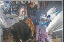  ??  ?? Santa, 25, from the Ivory Coast and her 5-year-old daughter,Timi, undergo an antigen test to ensure they aren’t carriers of the covid-19 virus after being rescued.