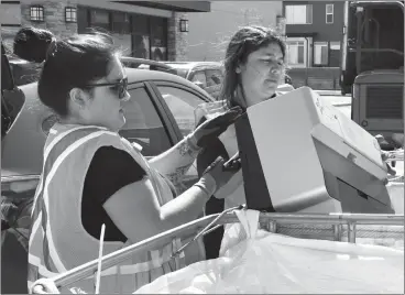  ?? HERALD PHOTO BY JUSTIN SEWARD ?? Tiare Marin and Andrea Aluarez of Ecycle recycle an old printer during the Ecycle Drive over the weekend at the westside Save-OnFoods location.