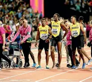  ??  ?? Left, Usain Bolt pulls up with a hamstring injury on the final leg of the 4x100m relay at the world championsh­ips, leaving the Jamaican superstar sprawled on the track and being consoled by team-mates in his last competitiv­e race.