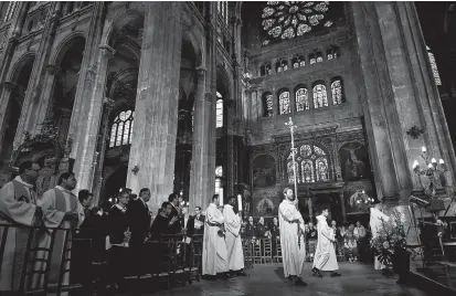  ??  ?? People attend mass in tribute to the Notre-Dame de Paris Cathedral at the Saint-Eustache church in Paris on Easter Sunday. A huge fire swept through the famed cathedral on April 15. — AFP